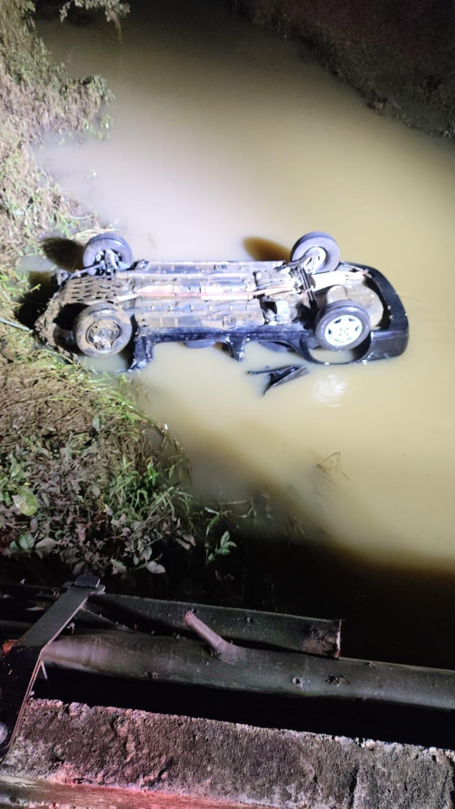 Motorista morre após carro sair da pista, capotar e cair em rio